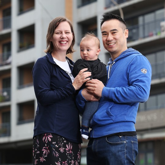 Man, woman and young child in front of an apartment building